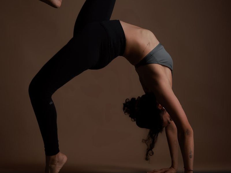 Person practicing yoga in a dark studio with neon highlights